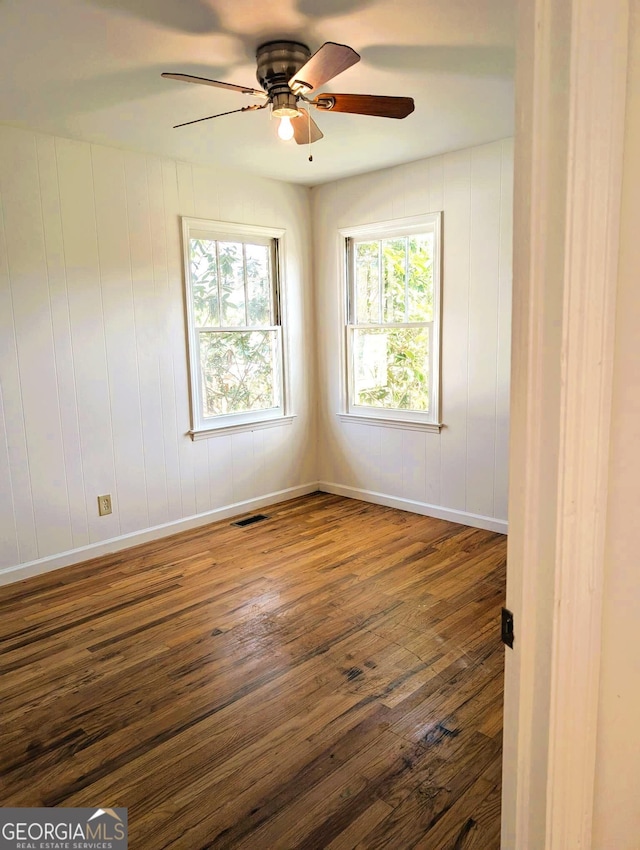 empty room featuring ceiling fan and dark hardwood / wood-style floors