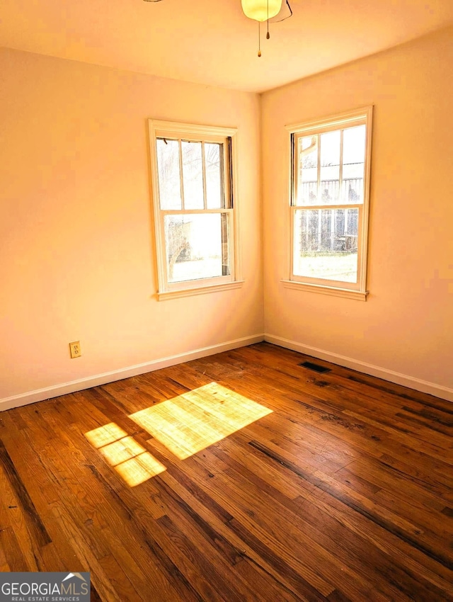 spare room with hardwood / wood-style flooring and plenty of natural light