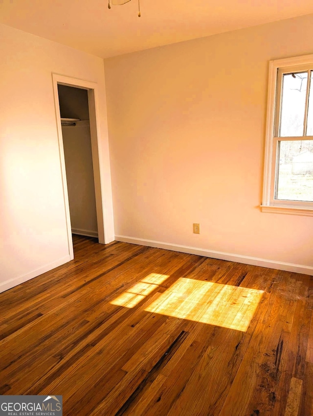 unfurnished bedroom featuring dark hardwood / wood-style flooring and a closet