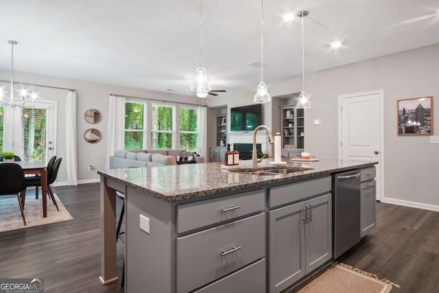 kitchen with stainless steel dishwasher, dark wood-style flooring, gray cabinets, and a sink