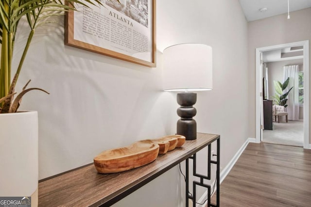 hallway featuring wood finished floors and baseboards