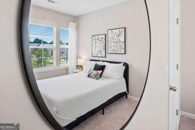 carpeted bedroom featuring visible vents and baseboards