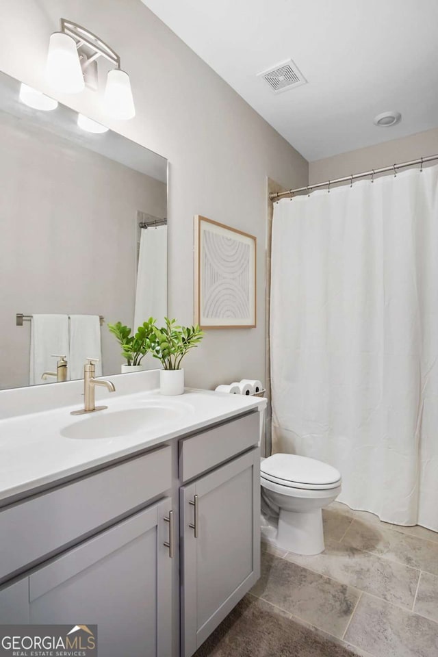 full bathroom featuring toilet, visible vents, and vanity