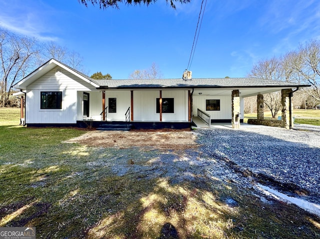 rear view of house with a lawn, a carport, and a porch