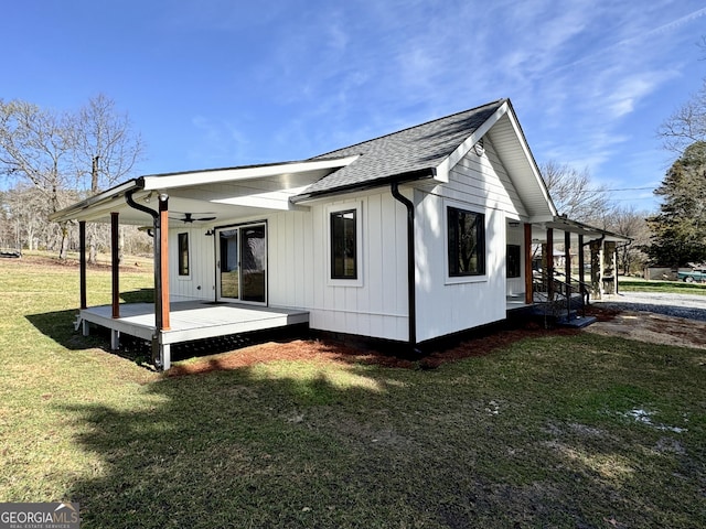 back of property with a lawn and a porch