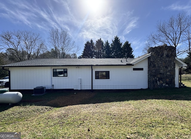 back of property featuring a yard and central AC