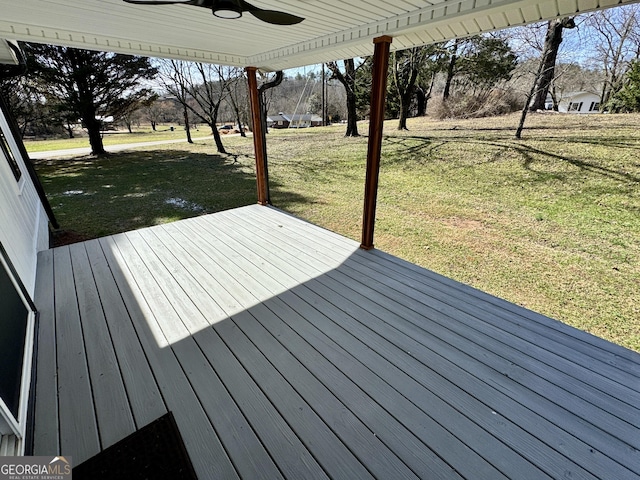 wooden deck with ceiling fan and a yard