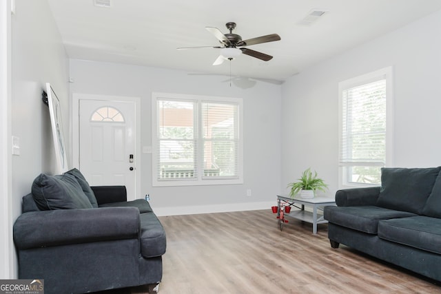 living room with light hardwood / wood-style flooring and ceiling fan