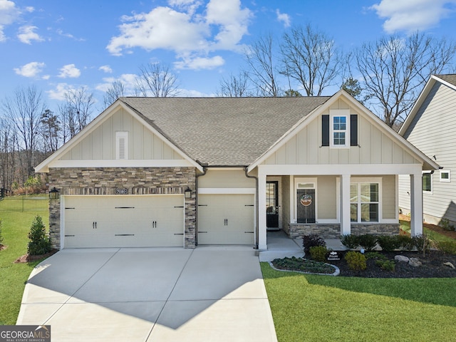 craftsman inspired home featuring stone siding, an attached garage, covered porch, board and batten siding, and a front yard