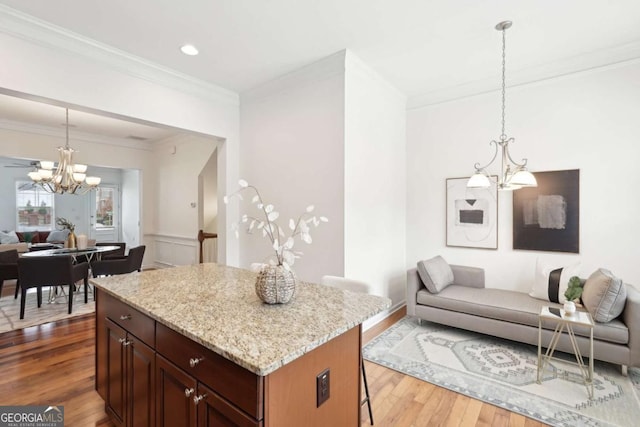 kitchen featuring a kitchen bar, decorative light fixtures, a chandelier, and a kitchen island