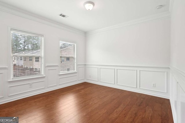 empty room with dark wood-type flooring and ornamental molding