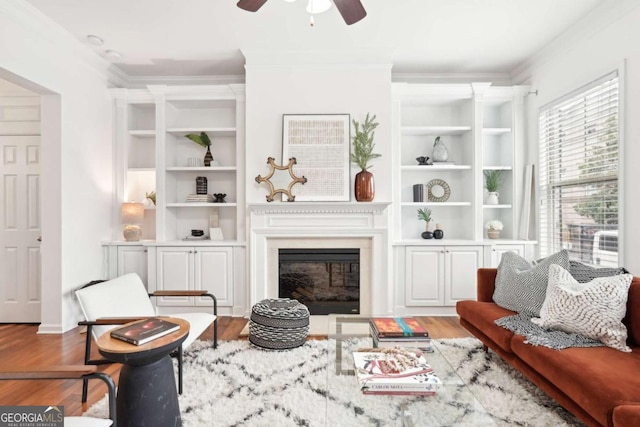 living area featuring ornamental molding, hardwood / wood-style floors, and built in features