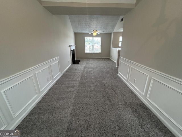 interior space featuring a textured ceiling, carpet floors, and ceiling fan