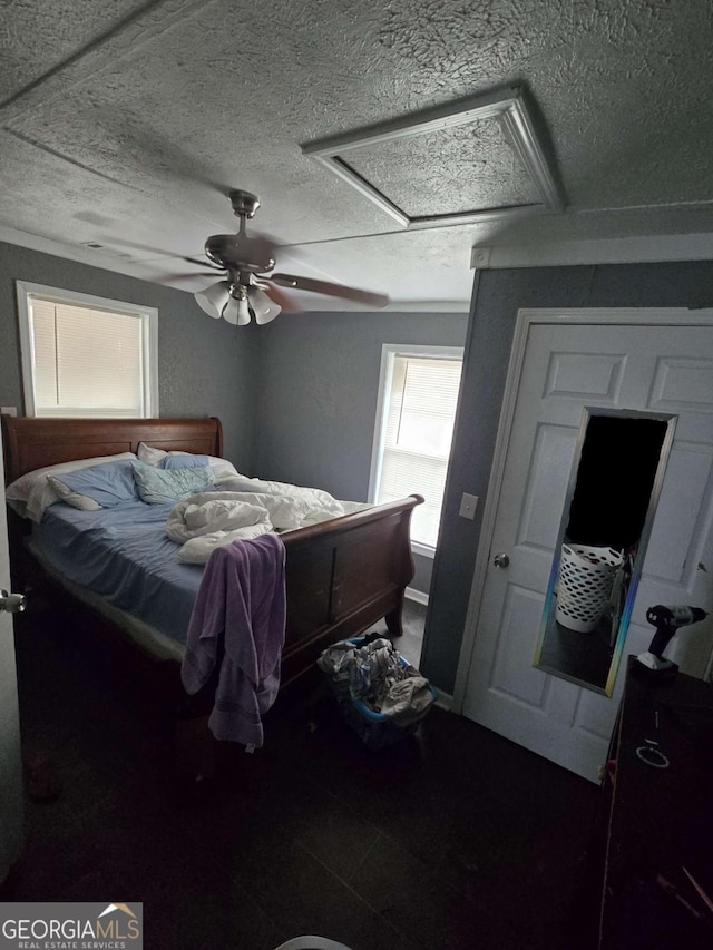 bedroom featuring ceiling fan and a textured ceiling