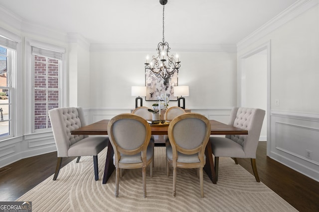 dining room featuring crown molding, hardwood / wood-style floors, and a chandelier