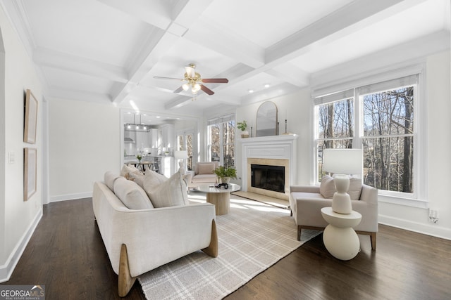 living room featuring wood-type flooring, coffered ceiling, a tiled fireplace, and beam ceiling