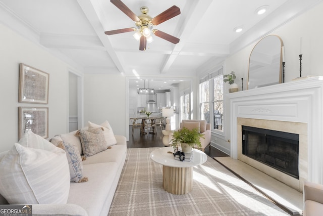 living room with ceiling fan, wood-type flooring, coffered ceiling, and beam ceiling