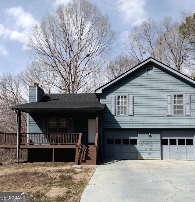 tri-level home featuring an attached garage, covered porch, driveway, and a chimney