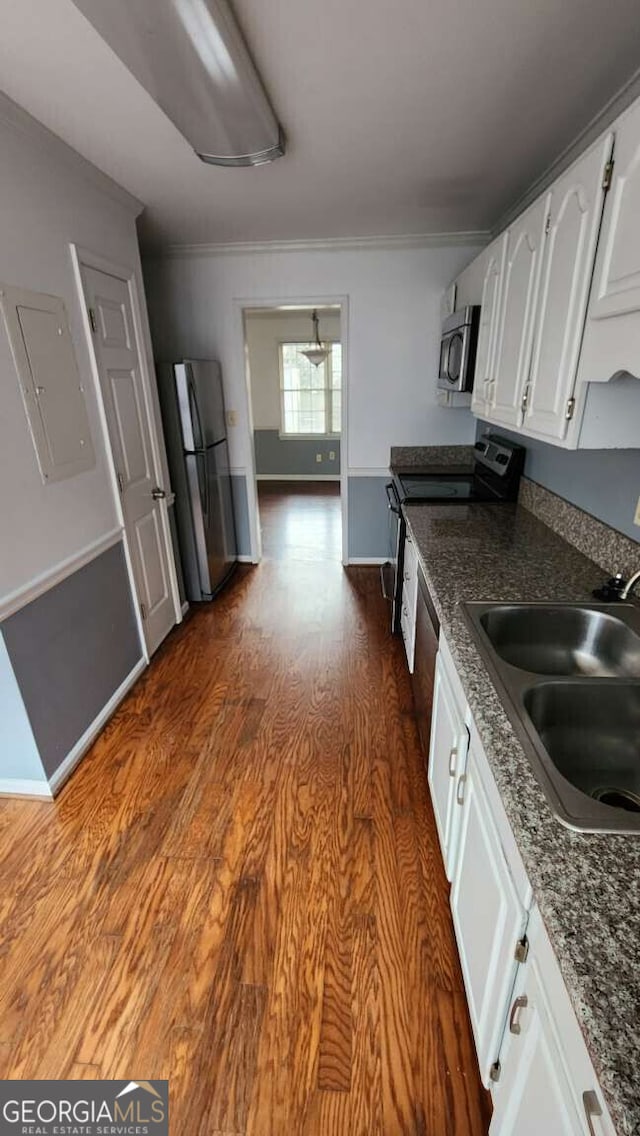 kitchen featuring sink, appliances with stainless steel finishes, white cabinetry, electric panel, and dark hardwood / wood-style floors