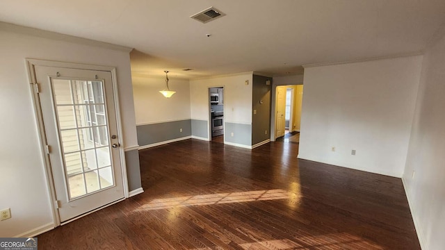 spare room with crown molding and dark wood-type flooring