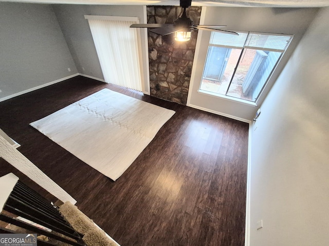 unfurnished living room with dark wood-type flooring and ceiling fan