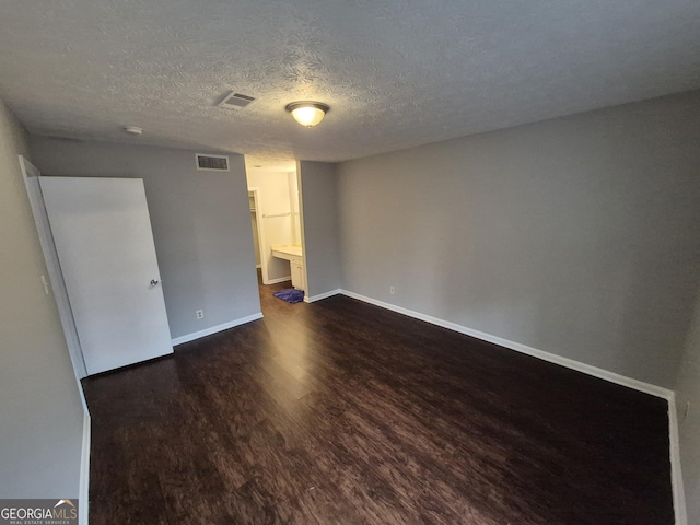 unfurnished bedroom with dark wood-type flooring and a textured ceiling