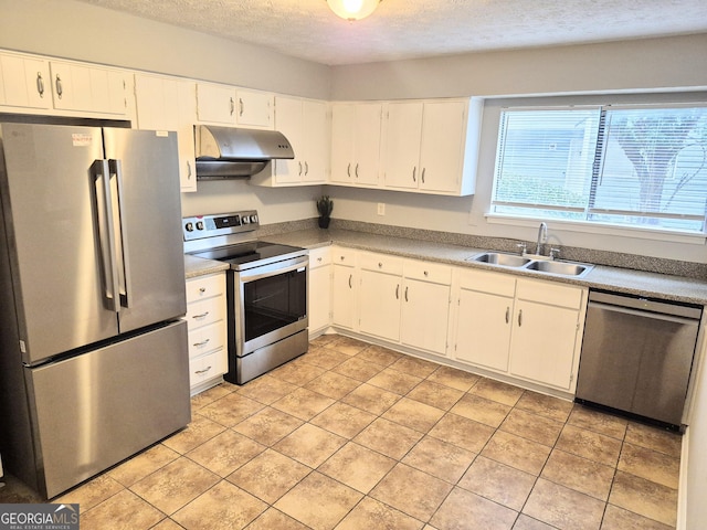 kitchen featuring appliances with stainless steel finishes, a textured ceiling, under cabinet range hood, white cabinetry, and a sink