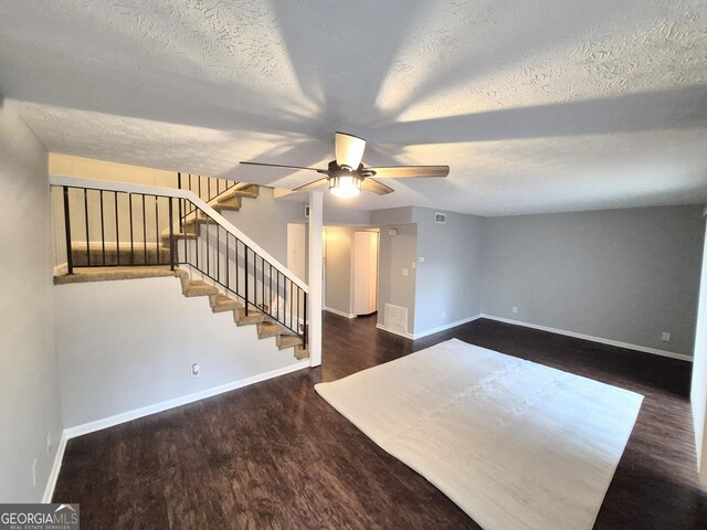 interior space with ceiling fan, a textured ceiling, and dark hardwood / wood-style flooring