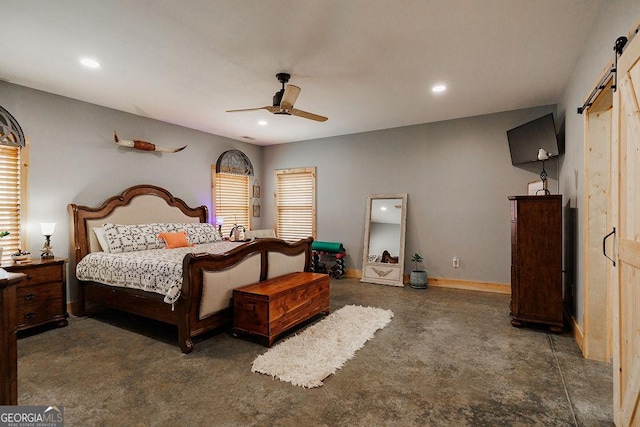 bedroom with ceiling fan and a barn door