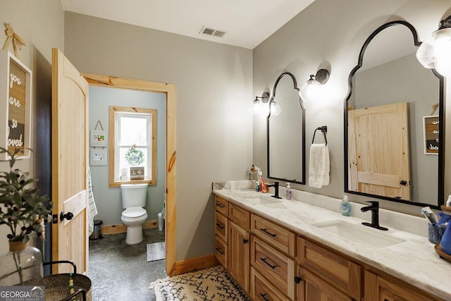 bathroom with vanity, concrete floors, and toilet