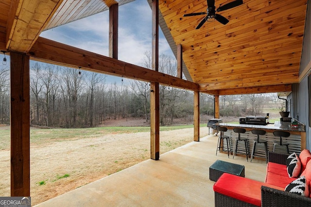 view of patio featuring exterior bar and ceiling fan