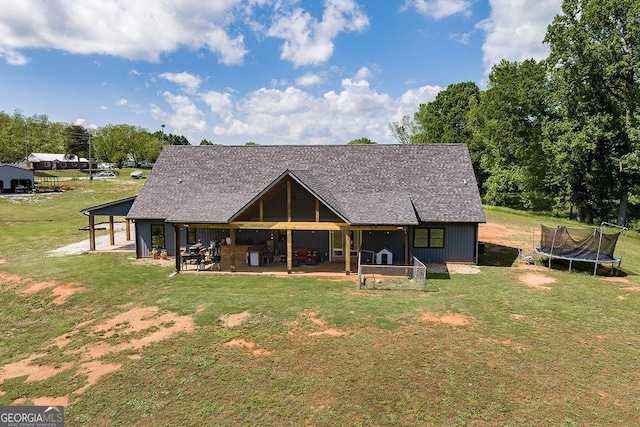 4059 Wildcat Bridge Rd, Royston, GA 30662 - rear view of property featuring a patio, a trampoline, roof with shingles, and a yard