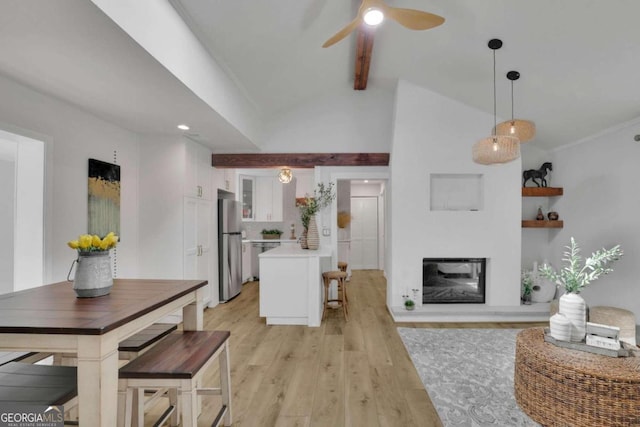 interior space with ceiling fan, light hardwood / wood-style flooring, and vaulted ceiling with beams