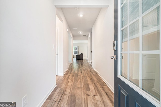 hallway with light hardwood / wood-style floors