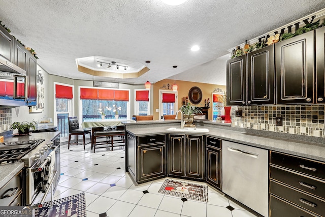 kitchen with hanging light fixtures, stainless steel appliances, tasteful backsplash, kitchen peninsula, and a raised ceiling