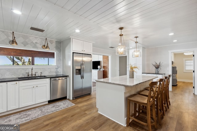 1142 New Point Peter Rd, Saint Marys, GA 31558 - kitchen featuring stainless steel appliances, a sink, wood ceiling, tasteful backsplash, and a center island