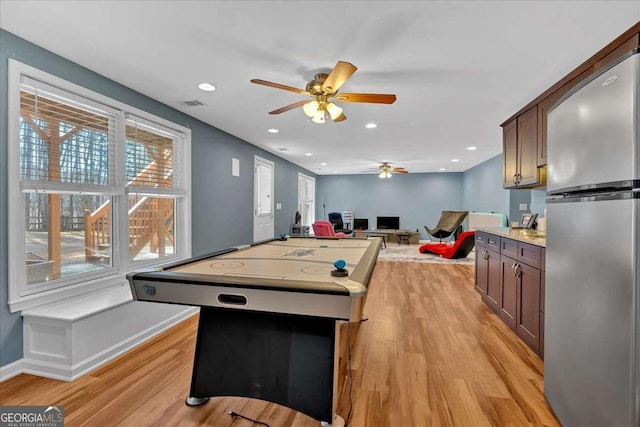 recreation room with ceiling fan and light wood-type flooring