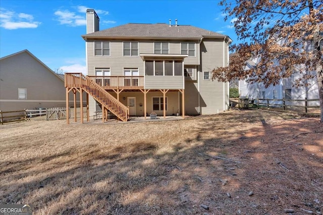 rear view of house featuring a sunroom and a deck