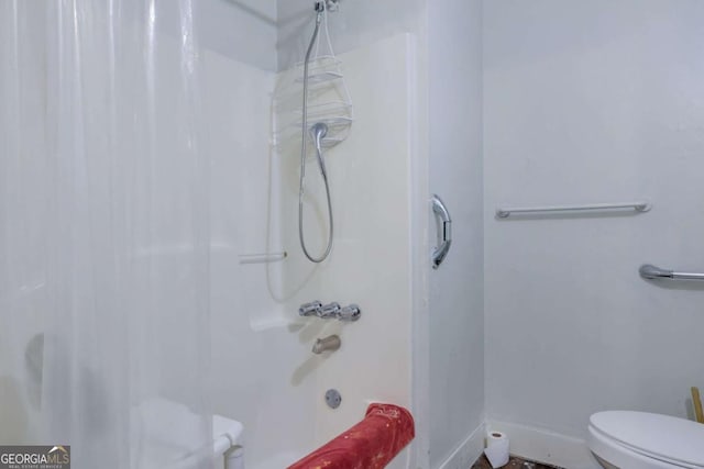 bathroom featuring washtub / shower combination and toilet