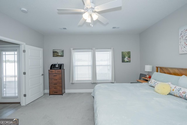 carpeted bedroom featuring ceiling fan and multiple windows