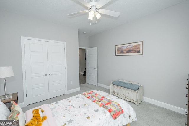 bedroom featuring light colored carpet, a closet, and ceiling fan