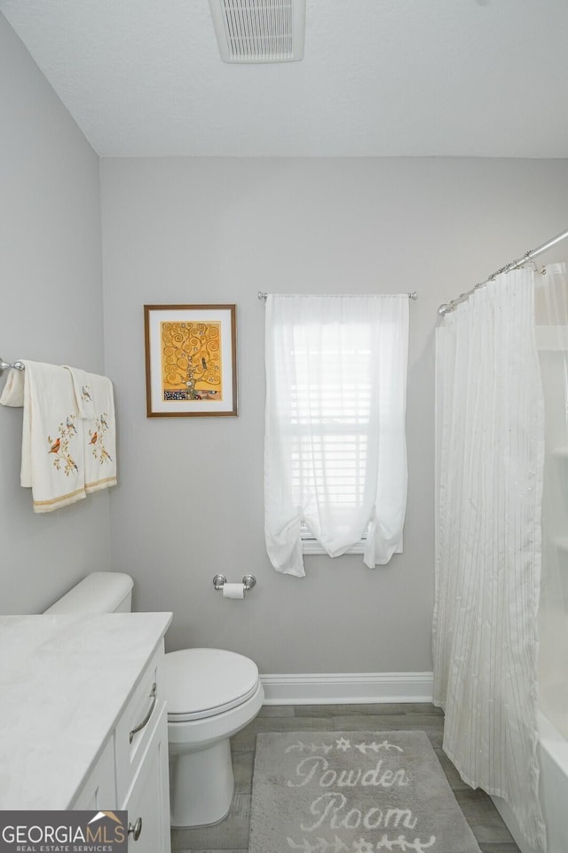 full bathroom featuring vanity, wood-type flooring, shower / bath combo, and toilet