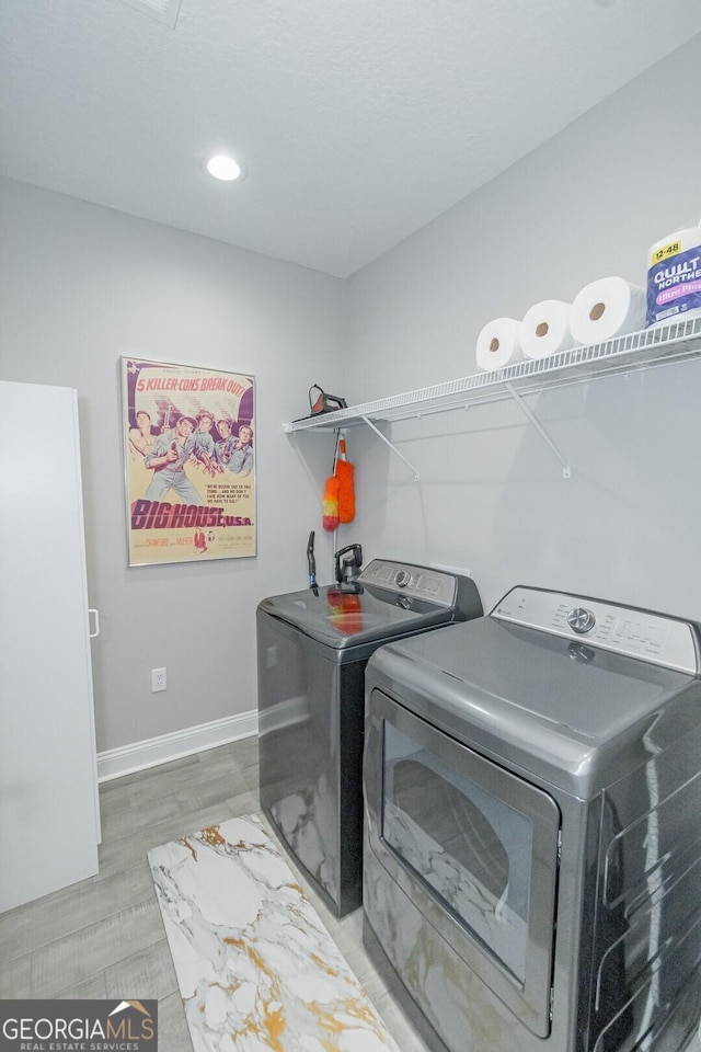 laundry area featuring separate washer and dryer and hardwood / wood-style floors