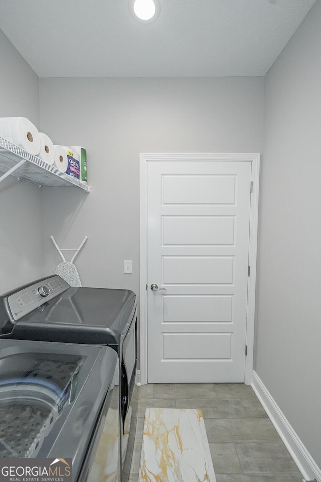 clothes washing area featuring hardwood / wood-style flooring and washer and clothes dryer