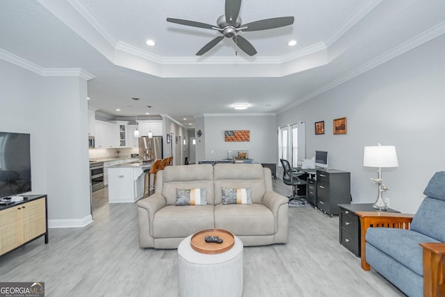 living room with crown molding and a tray ceiling