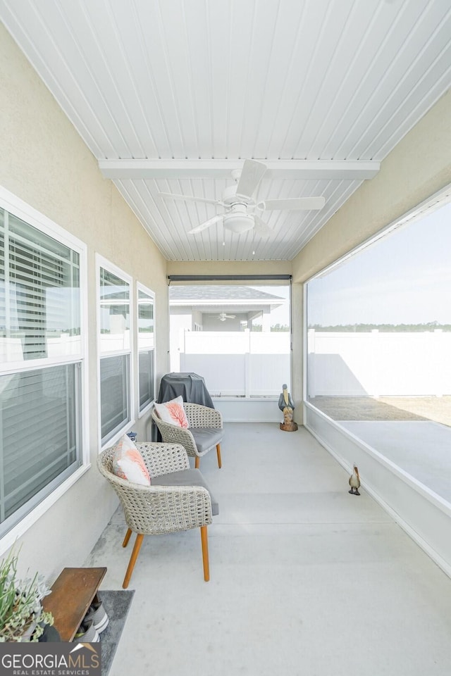 sunroom featuring a water view and ceiling fan