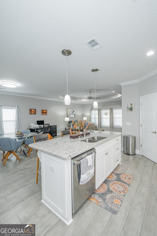 kitchen with decorative light fixtures, white cabinetry, dishwasher, sink, and a center island with sink