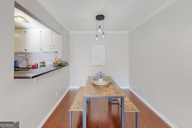 dining room featuring ornamental molding, wood-type flooring, and sink