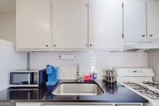 kitchen with backsplash, sink, white range with gas stovetop, and white cabinets