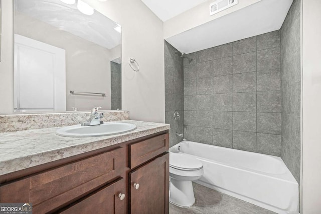 full bathroom featuring tiled shower / bath, vanity, toilet, and tile patterned floors